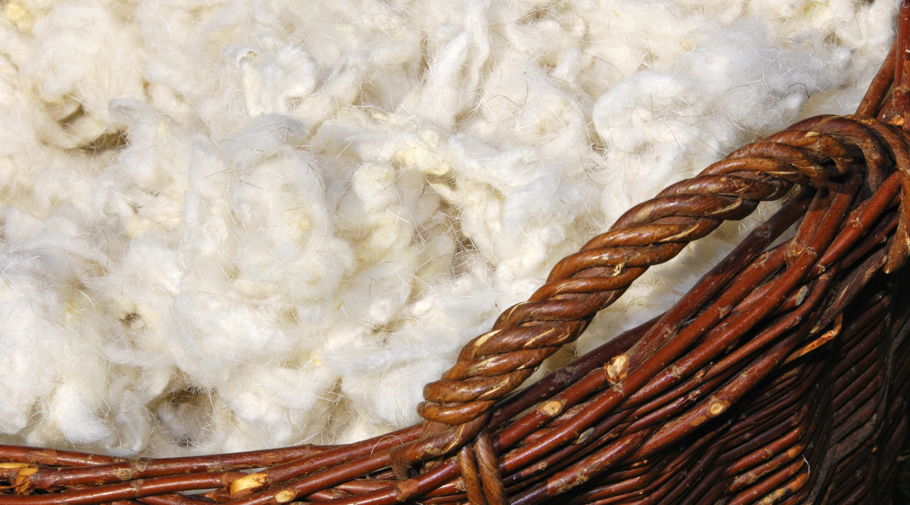 panier en osier rempli de laine de mouton de couleur blanche